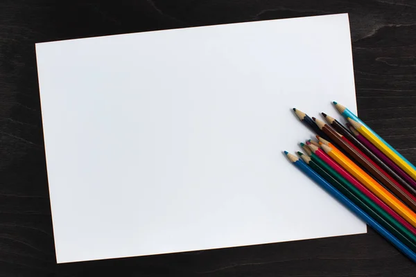 Renkli kalemler ve kağıt ahşap masa üzerinde çalışma alanı