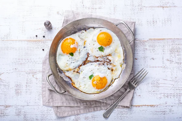 Huevos fritos sobre fondo de madera blanca — Foto de Stock