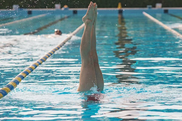 수영장에서 거꾸로 동기화 수영을 연습하는 여성의 — 스톡 사진