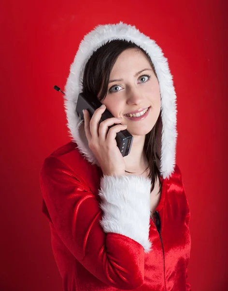 Рождественская женщина разговаривает по телефону на красном фоне . — стоковое фото
