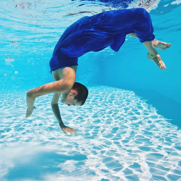 Retrato de mulher subaquática com vestido azul na piscina . — Fotografia de Stock