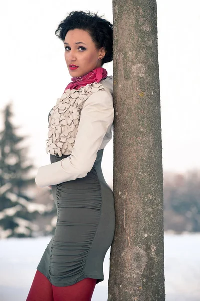 Porträtt av vacker flicka på vintern i närheten ett träd. — Stockfoto