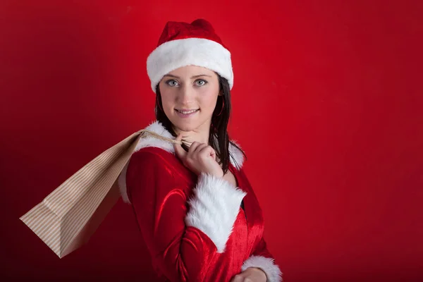Jul kvinna som innehar gåva isolerad på röd bakgrund. — Stockfoto