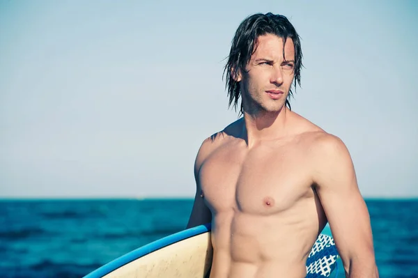 Forte jovem surfista retrato homem na praia com uma prancha de surf . — Fotografia de Stock