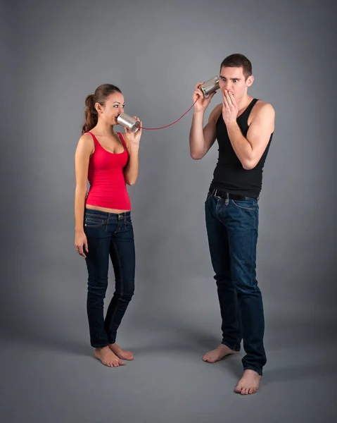 Young Couple Talking Tin Can Telephone Grey Background — Stock fotografie