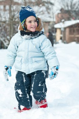 Portrait of young kid walking in the snow. 