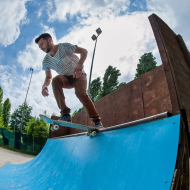 Halfpipe skatepark, üzerinden aşağı yuvarlanan kaykaycı. 