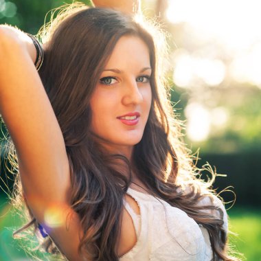 Beautiful brunette girl outdoors backlight portrait. 
