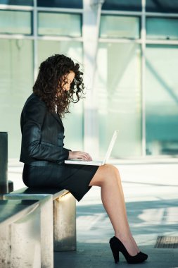 İş kadını dizüstü bilgisayar kullanarak dışarıda. Tam gövde portresi.