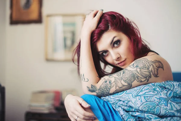 Sensual portrait of beautiful girl with tattoo lying on bed. — Stock Photo, Image