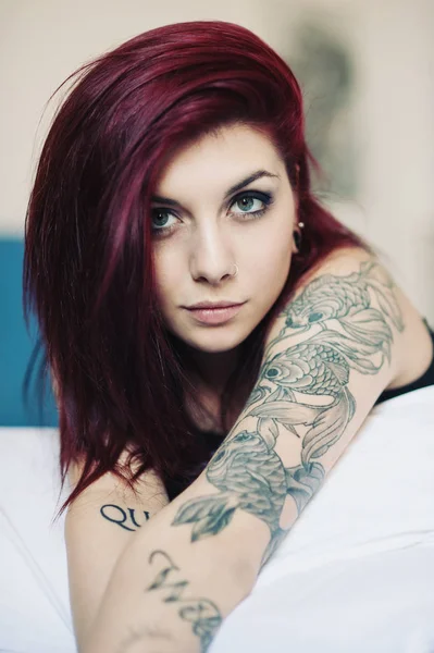 Portrait sensuel de belle fille avec tatouage couché sur le lit . — Photo