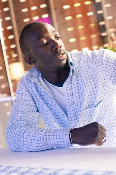 Young african man having a drink in a bar. — Stock Photo, Image