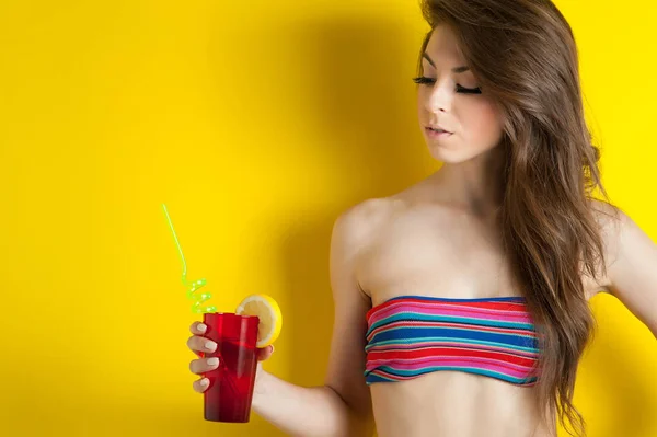 コピースペースで黄色の背景にカクテルを飲む美しい女の子 — ストック写真