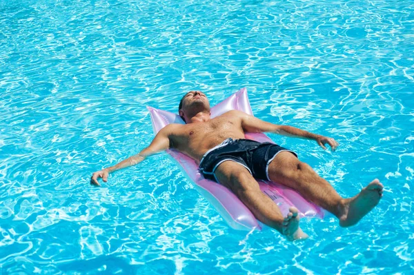 Giovane uomo rilassante sulla piscina . — Foto Stock