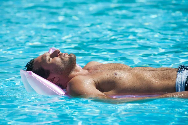 A fiatalember pihentető a medence mellett. — Stock Fotó