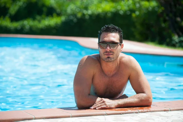 Portrait of a handsome and happy man relaxing at the side of a s — Stock Photo, Image