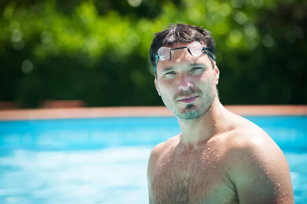 Portrait of a handsome man with goggles in swimming pool. — Stock Photo, Image