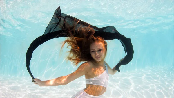 スイミングプールで黒いベールを持つ水中女性のファッションの肖像画 — ストック写真
