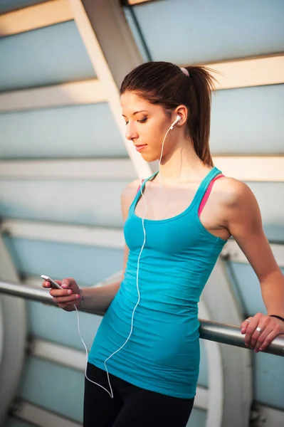若い女性リラックス屋外で現代的な橋の上に音楽を聴きながら — ストック写真