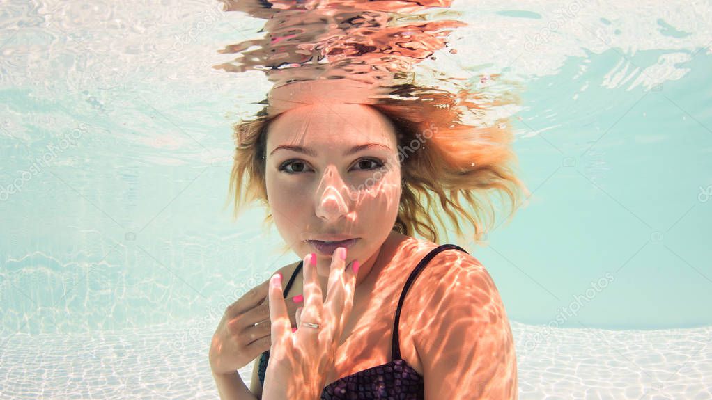 Beautiful woman portrait underwater in swimming pool. 