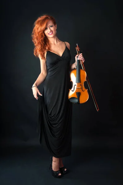 黒を背景にヴァイオリンを持つ若い女性 全身像 — ストック写真