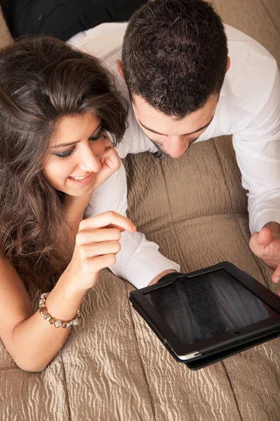 快乐的年轻夫妇在酒店房间用平板电脑放松 — 图库照片