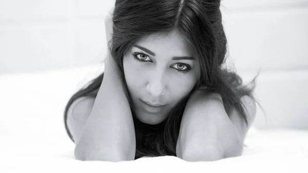 强烈的年轻女子肖像 而躺在床上的酒店房间 浅景深 黑白图像模拟胶片效果 — 图库照片