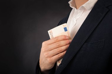 siyah arka plan karşı euro banknotlar ile resmi giyim adam.