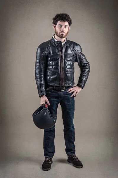 Selbstbewusster junger Mann mit Lederjacke und Helm. — Stockfoto