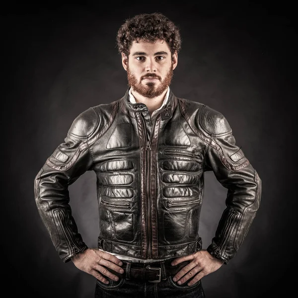 Portrait of confident young man wearing leather jacket against b — Stock Photo, Image