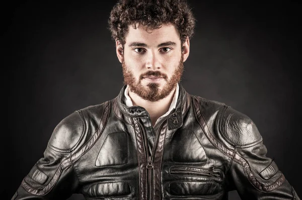 Portrait of confident young man wearing leather jacket against b — Stock Photo, Image