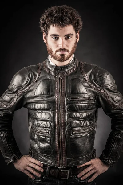 Portrait of confident young man wearing leather jacket against b — Stock Photo, Image