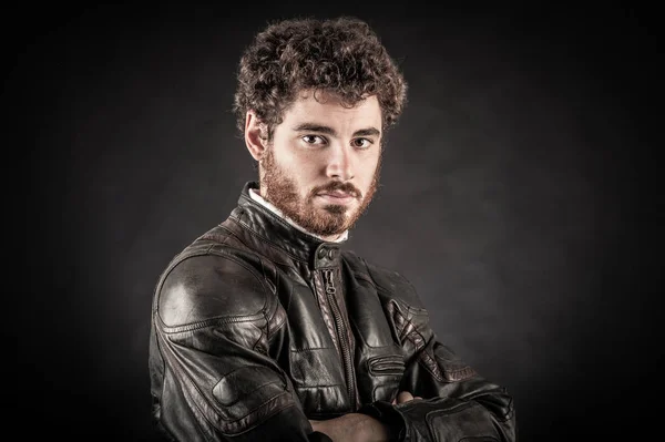 Portrait of confident young man wearing leather jacket against b — Stock Photo, Image