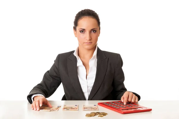 Young businesswoman calculating savings against white background — Stock Photo, Image