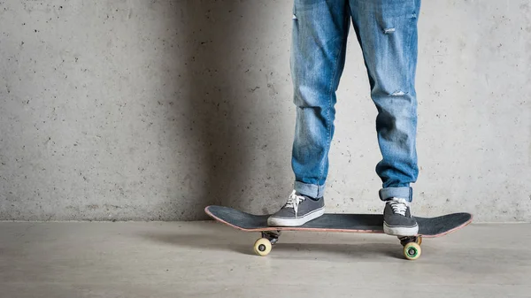Skateboarder Standing Skateboard Wearing Jeans Keds Concrete Wall — Stock Photo, Image