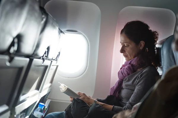 Женщина Читает Книгу Внутри Самолета — стоковое фото