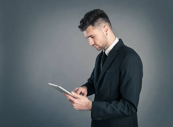 Joven Hombre Negocios Mirando Tableta Contra Fondo Oscuro — Foto de Stock