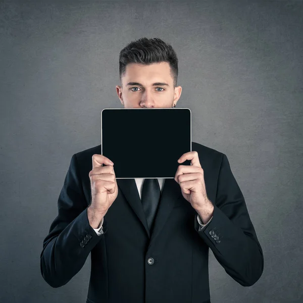 Jonge Zakenman Toont Tablet Tegen Donkere Grunge Achtergrond — Stockfoto