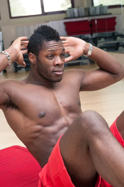 Young black african man portrait exercising abdominal muscles at — 스톡 사진
