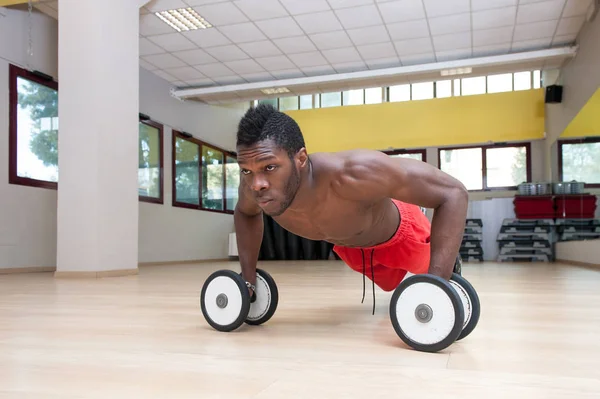 Jovem preto homem retrato fazendo push up exercício com halteres em — Fotografia de Stock