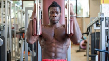 Young black man portrait exercising at the gym. 
