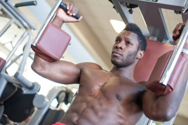 Young black man portrait exercising at the gym. 