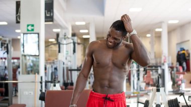 Spor salonunda egzersiz yaparken gülümseyen siyah adam portre. 