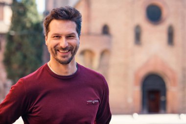 Mutlu genç adam şehir merkezinde portre açık yakın 