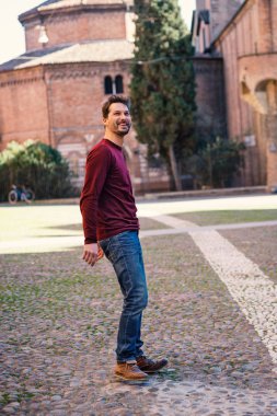 Şehir merkezinde gülümseyen genç adam tam vücut portre açık 
