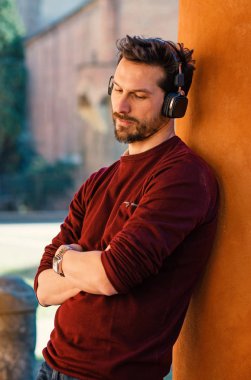 Young man with headphones close up portrait outdoor in the city 