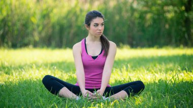 Genç kadın portre pratik yoga açık havada içinde bir park. 