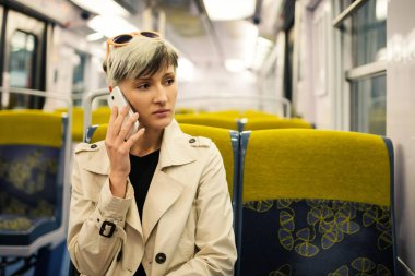 Metroda genç bir kadın telefonda konuşuyor. Paris, Fransa.