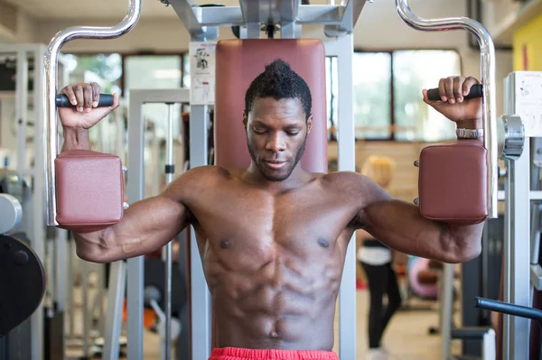 Сильный молодой чернокожий мужчина тренируется в спортзале . — стоковое фото