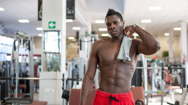 Sterke zwarte man met een pauze in de sportschool. — Stockfoto